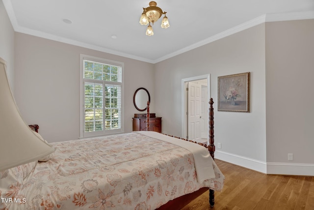 bedroom with baseboards, wood finished floors, and crown molding