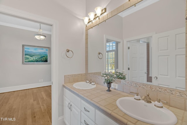 bathroom featuring ornamental molding, wood finished floors, and a sink