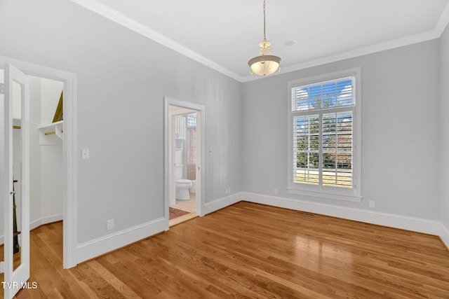 interior space featuring baseboards, ornamental molding, and wood finished floors