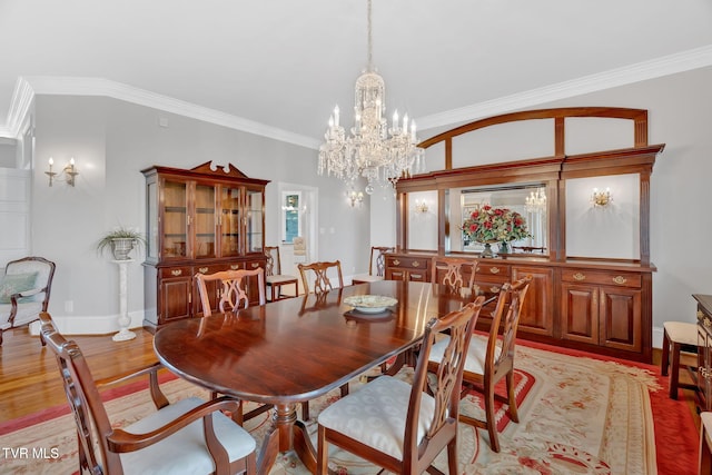 dining room with light wood finished floors, baseboards, crown molding, and an inviting chandelier