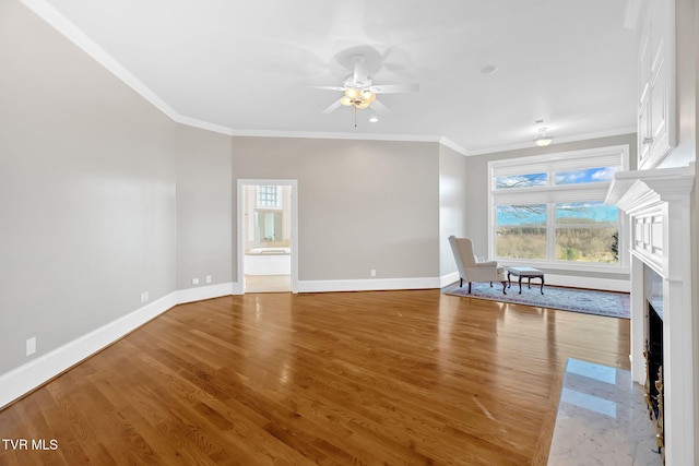 unfurnished living room with a healthy amount of sunlight, ornamental molding, and wood finished floors