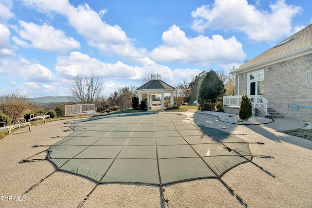 view of pool featuring a covered pool, a patio, and a gazebo