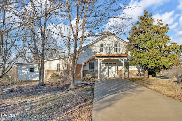 view of front of home featuring driveway, an attached garage, and brick siding