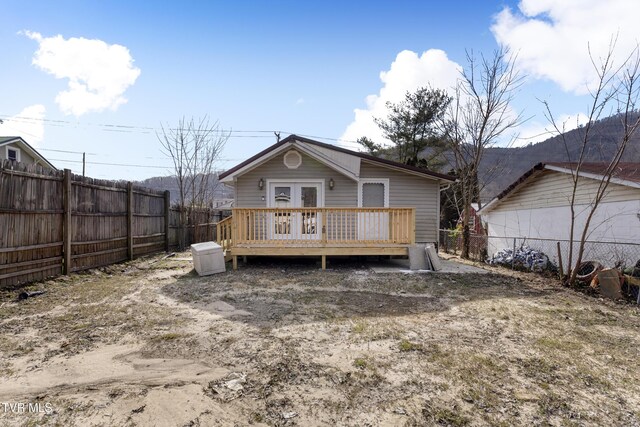 back of property featuring a fenced backyard, a wooden deck, and french doors