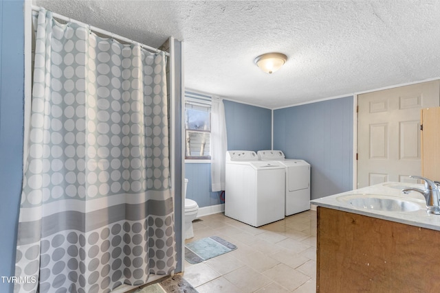 bathroom featuring a textured ceiling, separate washer and dryer, toilet, and a shower with curtain