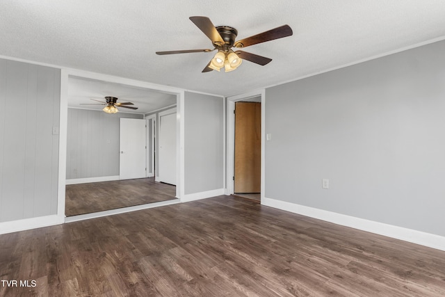 empty room with ceiling fan, a textured ceiling, baseboards, and wood finished floors