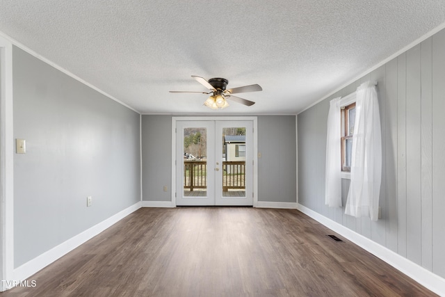 unfurnished room with a healthy amount of sunlight, visible vents, french doors, and dark wood-style flooring