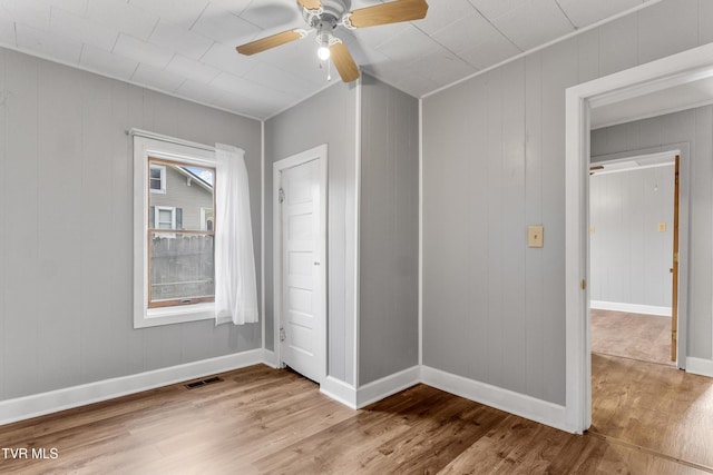 unfurnished bedroom with ceiling fan, wood finished floors, visible vents, and baseboards