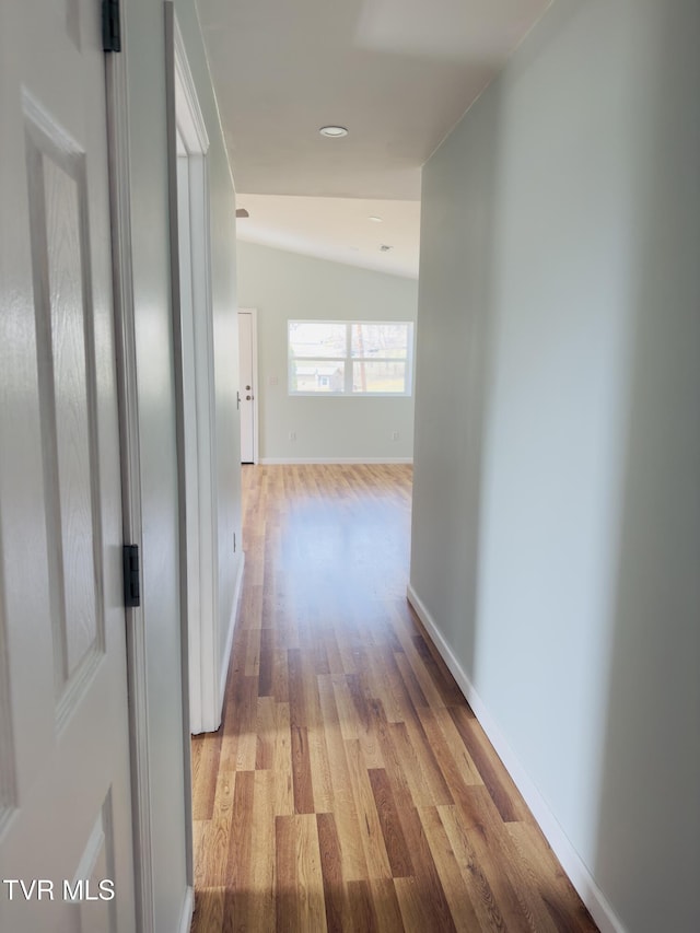 hallway with baseboards and light wood-style floors