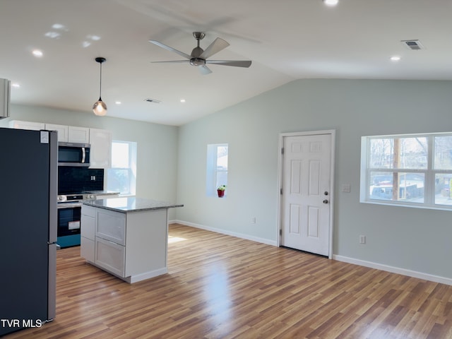 kitchen featuring ceiling fan, light wood-type flooring, and stainless steel appliances