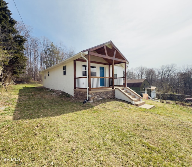 bungalow-style home with stucco siding, a porch, a front yard, and fence