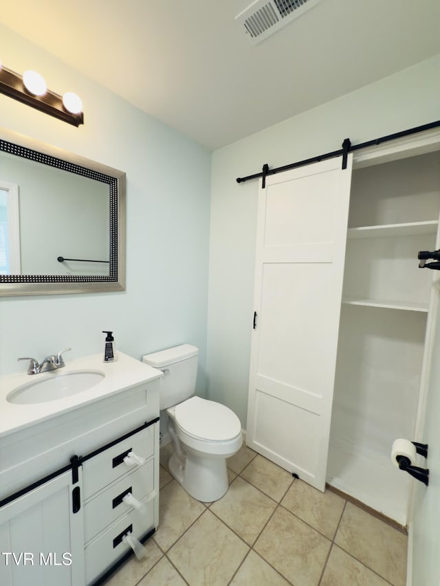 bathroom featuring vanity, toilet, visible vents, and tile patterned flooring