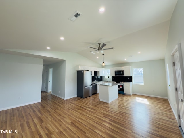 kitchen featuring visible vents, appliances with stainless steel finishes, open floor plan, and white cabinetry