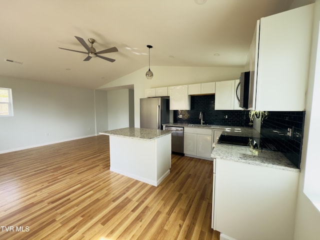 kitchen featuring visible vents, a sink, a center island, appliances with stainless steel finishes, and ceiling fan