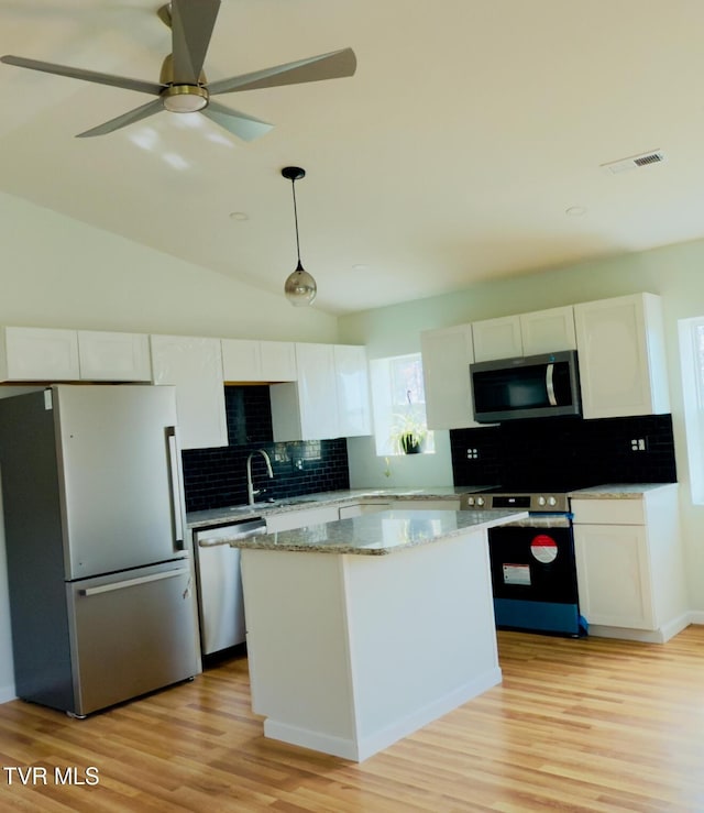 kitchen with visible vents, stainless steel appliances, light wood-style floors, white cabinetry, and a center island