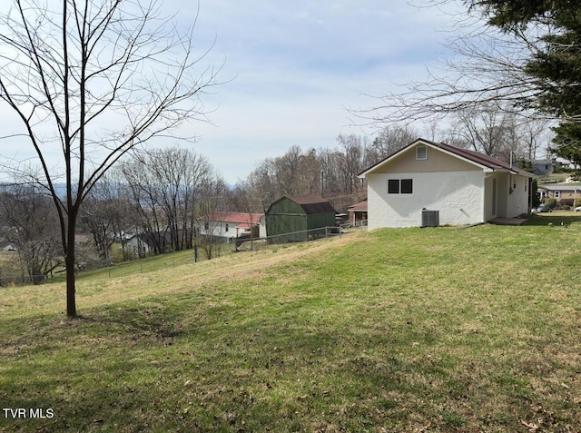 view of yard featuring an outdoor structure, cooling unit, and fence