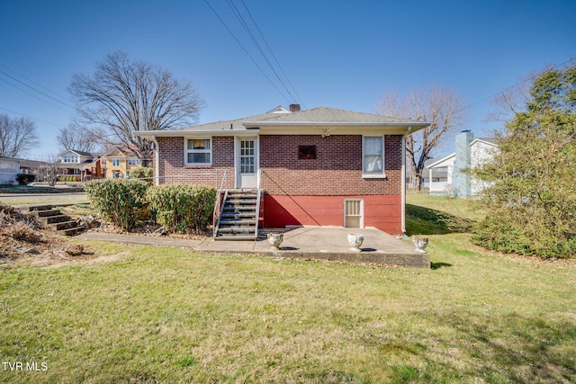 back of property featuring a yard, brick siding, and entry steps