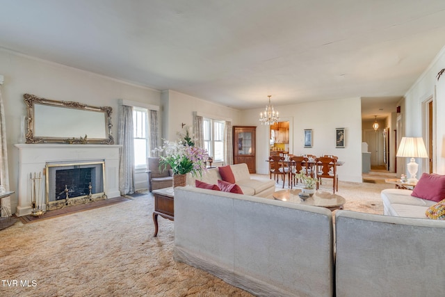 living room with ornamental molding, a fireplace, an inviting chandelier, and carpet floors