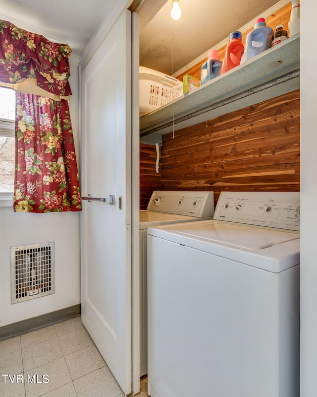 washroom with washer and clothes dryer, visible vents, and laundry area