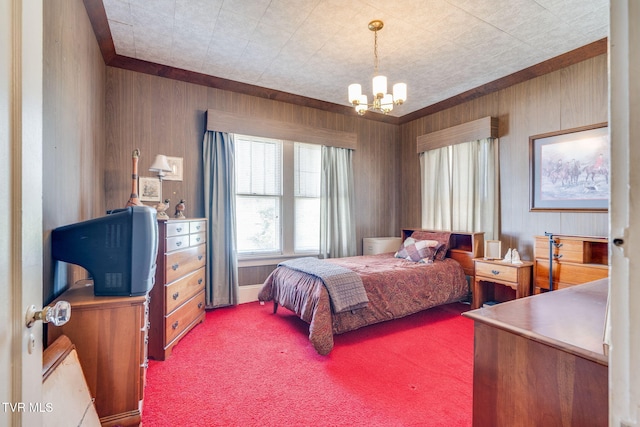 bedroom with a chandelier, carpet flooring, and wooden walls