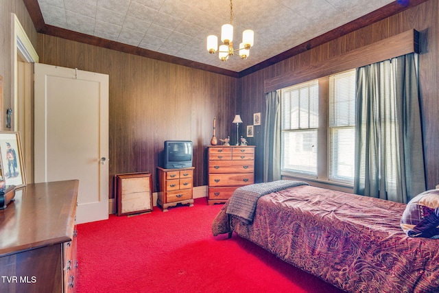 bedroom with a notable chandelier, wooden walls, and carpet floors