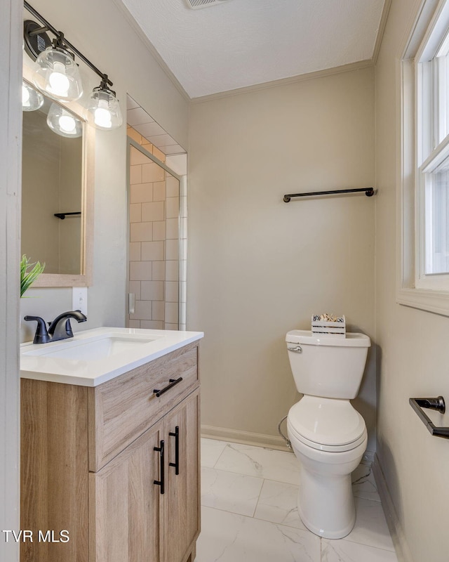 bathroom with baseboards, toilet, marble finish floor, crown molding, and vanity