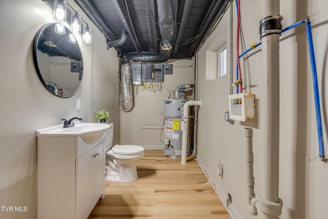 bathroom featuring water heater, vanity, toilet, and wood finished floors