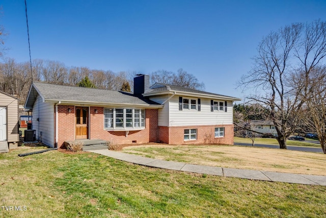 tri-level home with central AC unit, a chimney, a front yard, and brick siding