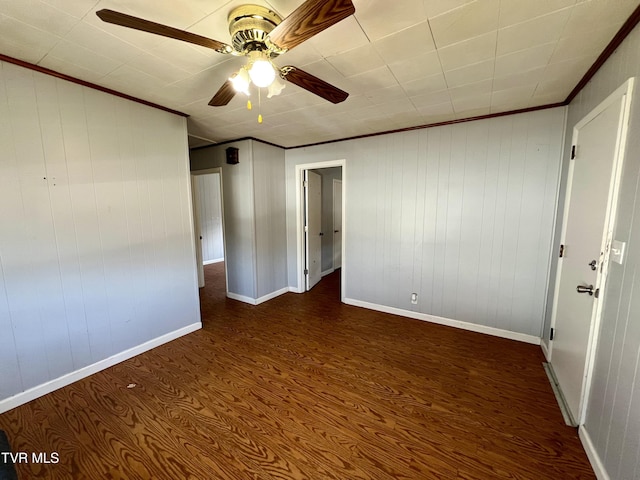 unfurnished bedroom with baseboards, a ceiling fan, dark wood-type flooring, and crown molding