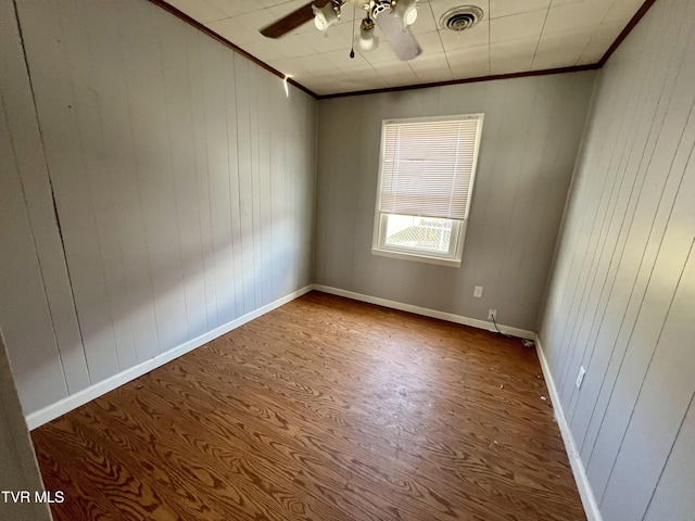 spare room featuring ceiling fan, visible vents, baseboards, and ornamental molding