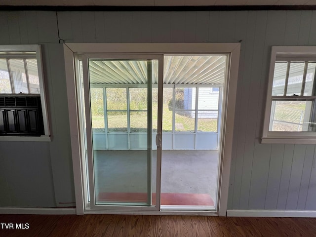 doorway to outside with a wealth of natural light, baseboards, and wood finished floors