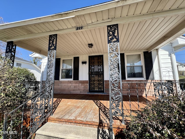 property entrance featuring covered porch and stone siding