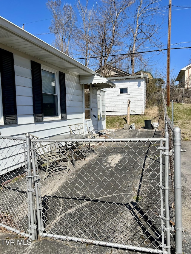 exterior space featuring an outbuilding, a gate, and fence