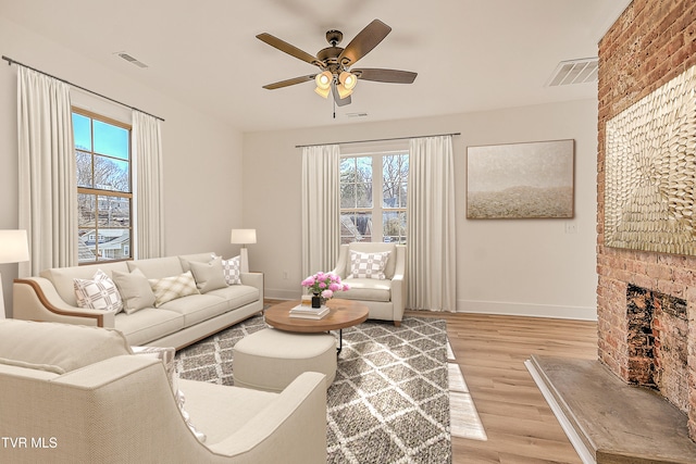living room featuring ceiling fan, a wealth of natural light, baseboards, and light wood-type flooring