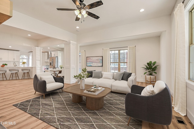 living area featuring a ceiling fan, ornate columns, visible vents, dark wood-type flooring, and recessed lighting