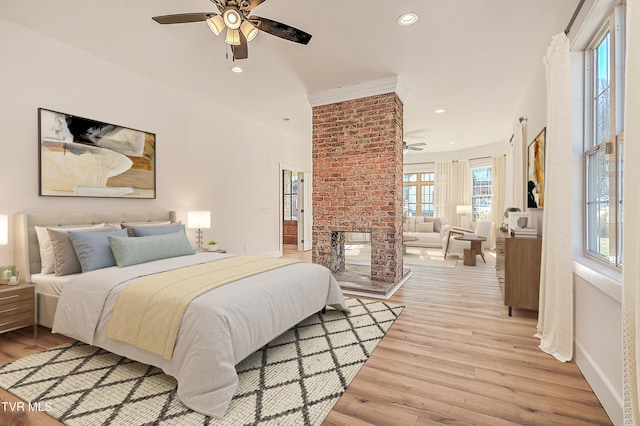 bedroom with recessed lighting, baseboards, ceiling fan, a brick fireplace, and light wood-type flooring