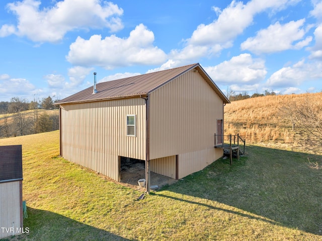 view of property exterior with metal roof and a lawn