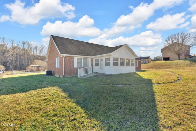 view of front of house featuring brick siding, a front lawn, and central air condition unit