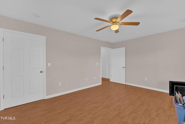 unfurnished bedroom featuring baseboards, ceiling fan, and light wood finished floors