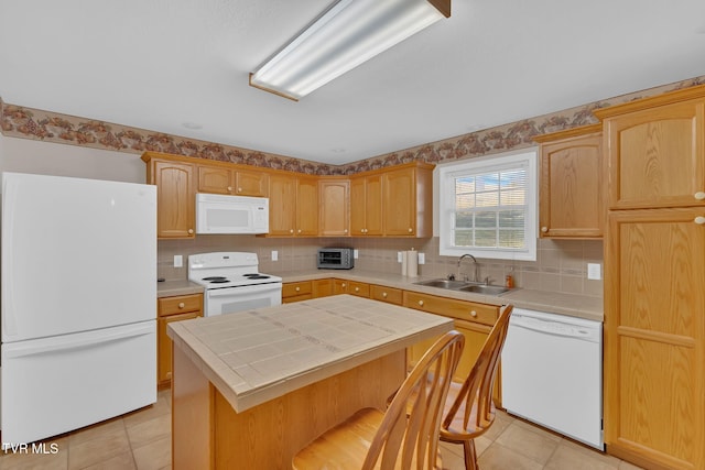 kitchen featuring a center island, light tile patterned floors, tile counters, a sink, and white appliances