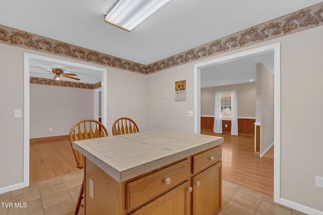 kitchen featuring tile counters, light tile patterned flooring, and ceiling fan