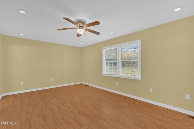 spare room with a ceiling fan, light wood-type flooring, baseboards, and recessed lighting