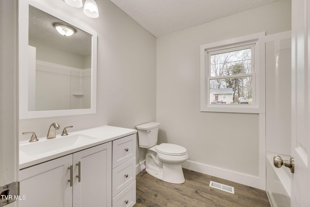 bathroom with visible vents, toilet, wood finished floors, a textured ceiling, and vanity