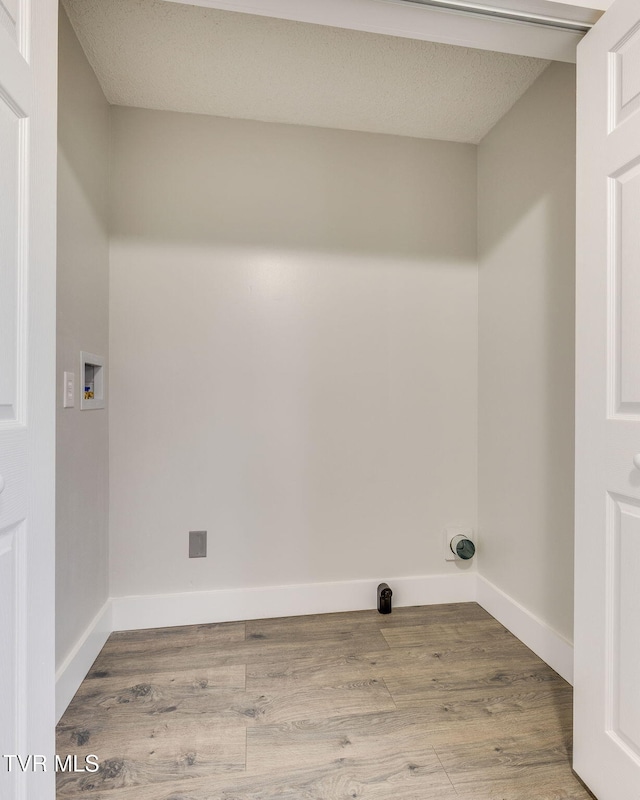 laundry room featuring laundry area, washer hookup, wood finished floors, and baseboards