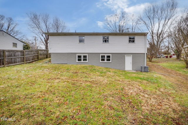 back of house featuring central AC unit, a lawn, and fence