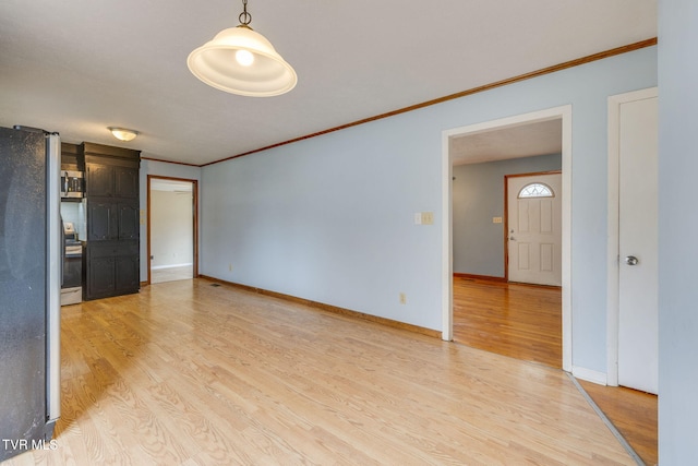 interior space with light wood-style flooring, baseboards, and crown molding