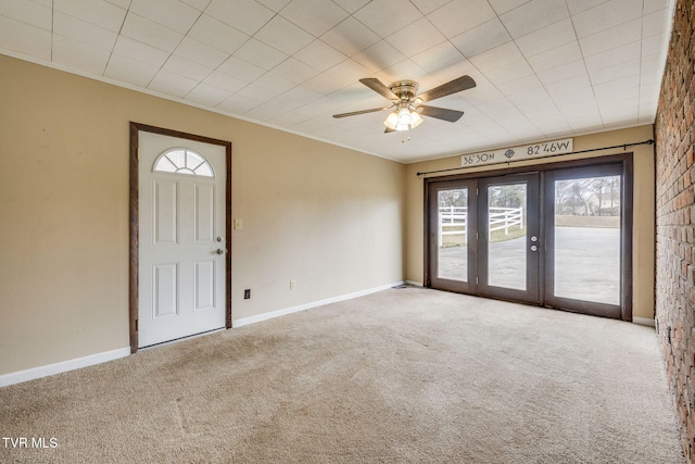 foyer entrance featuring ornamental molding, carpet, french doors, and baseboards