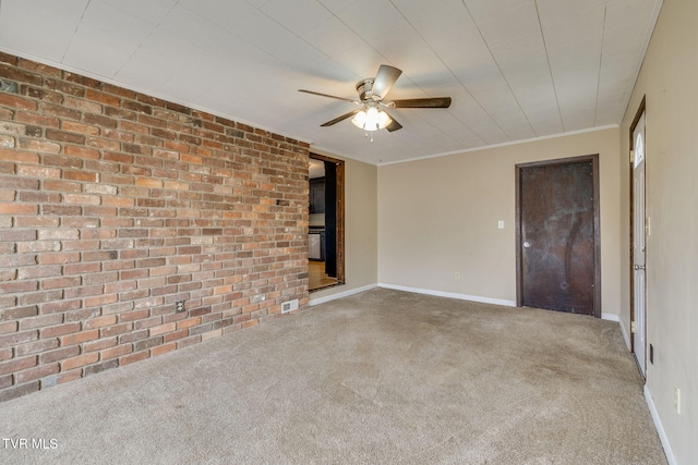 unfurnished room with a ceiling fan, brick wall, carpet flooring, and baseboards