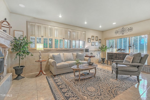 living room with light tile patterned floors, ornamental molding, a premium fireplace, and tile walls