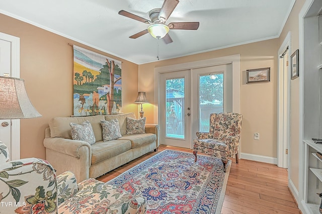 living room featuring a ceiling fan, baseboards, ornamental molding, french doors, and light wood finished floors